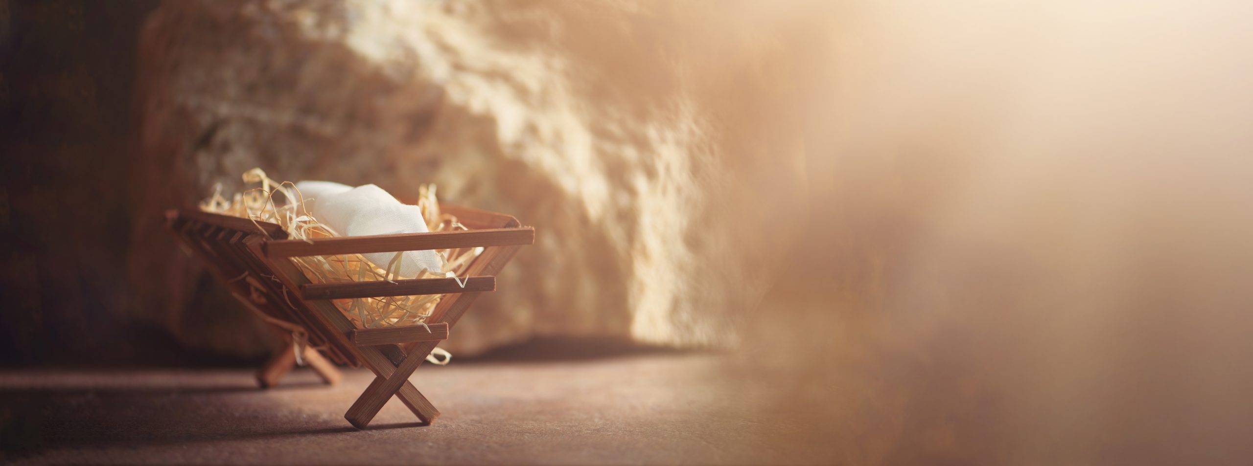 Wooden manger and star of Bethlehem in cave, nativity scene background